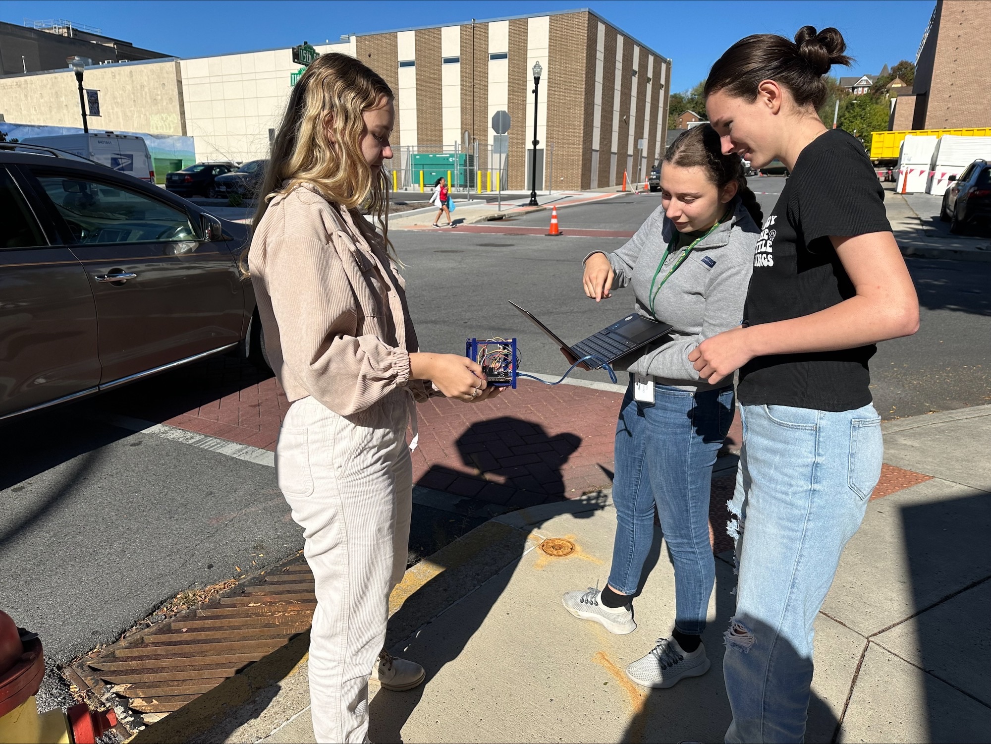 (From Left) Lucy Buchanan, '26, Pia Rock, '27, and Rebecca Lucy, 27, work on their satcube.